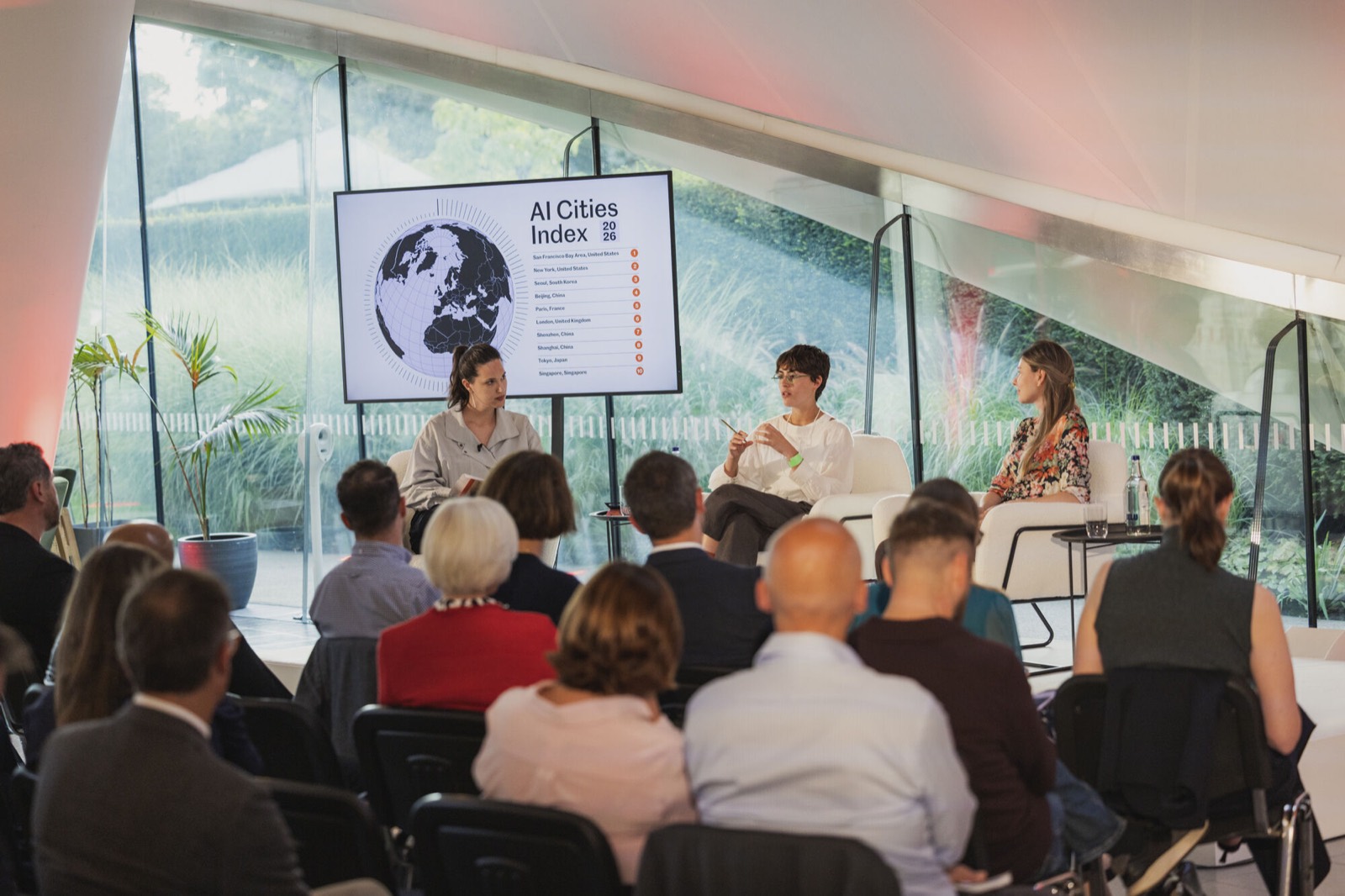 A full audience watching a panel at The Observer's Responsible AI Forum, with the AI Cities Index on screen